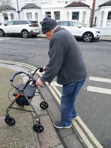A Keep Active client walking on the street with a walker